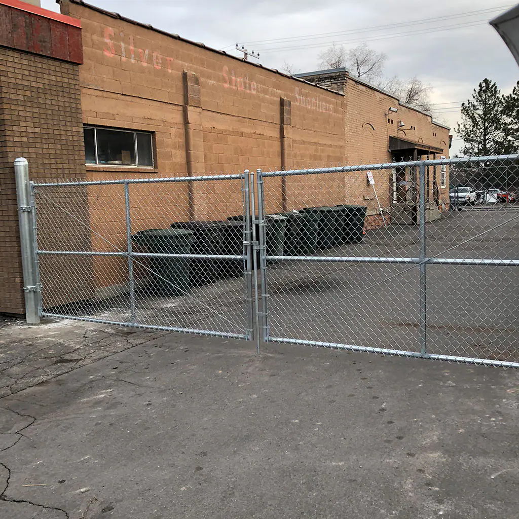 Black commercial metal fence installed around a Utah business property