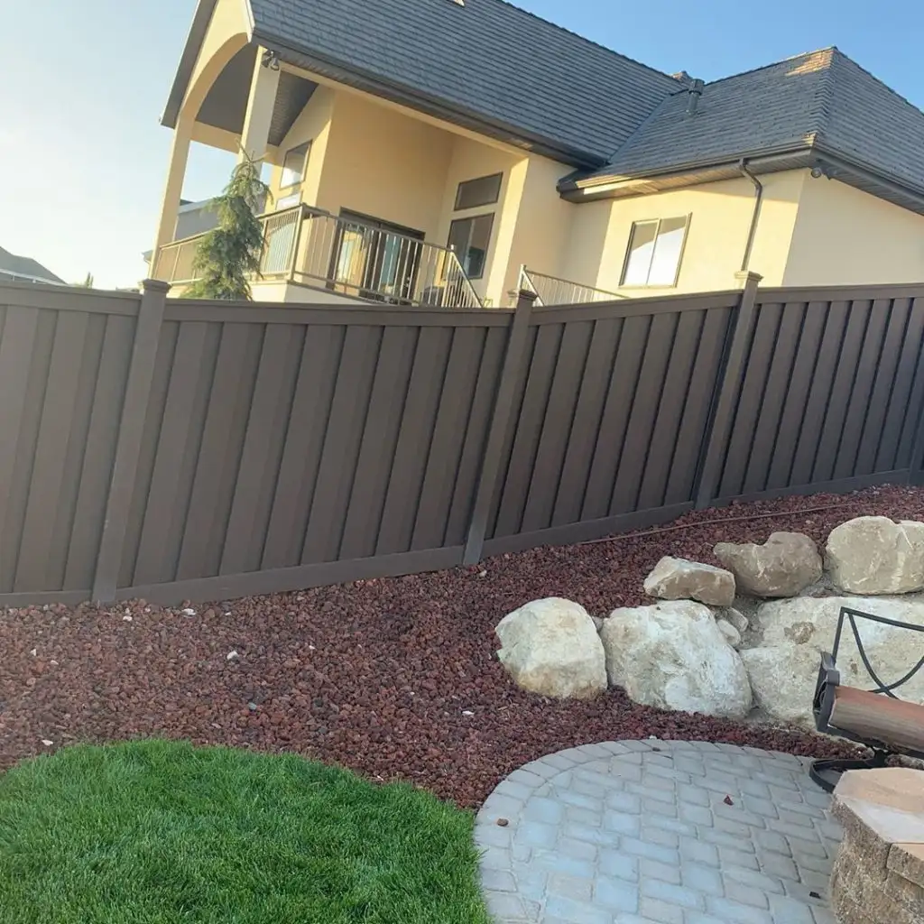 Dark Trex composite privacy fence installed around a landscaped Lehi, Utah backyard